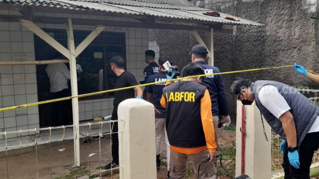 Petugas kepolisian kembali melakukan olah TKP di rumah kontrakan, lokasi penemuan sekeluarga tidak sadarkan diri Desa Ciketing Udik Kecamatan Bantar Gebang, Kota Bekasi (Suara.com / Danan Arya)
