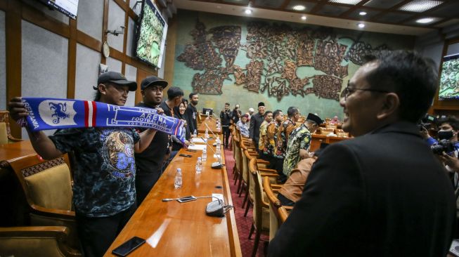 Ketua Komisi X DPR Syaiful Huda (kanan) menyapa sejumlah keluarga korban tragedi Stadion Kanjuruhan, Malang saat rapat dengar pendapat umum di Kompleks Parlemen, Senayan, Jakarta, Rabu (18/1/2023). [ANTARA FOTO/Rivan Awal Lingga].