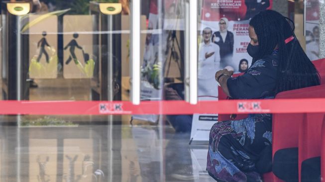 Istri dari Gubernur Papua nonaktif Lukas Enembe, Yulce Wenda duduk usai menjalani pemeriksaan di Gedung Merah Putih KPK, Jakarta, Rabu (18/1/2023). [ANTARA FOTO/M Risyal Hidayat]