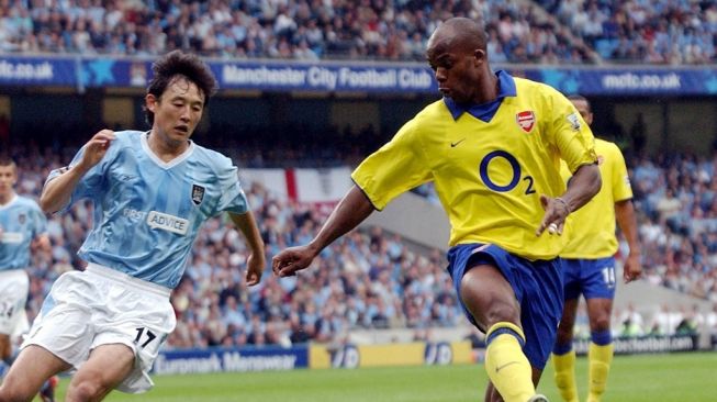 Pemain Arsenal Sylvain Wiltord (kanan) bersaing dengan Sun Jihai dari Manchester City selama pertandingan Premiership mereka di Stadion Manchester di Manchester, 31 Agustus 2003. FOTO AFP PAUL BARKERPAUL BARKER / AFP