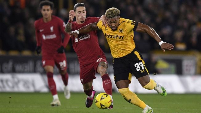 Pemain Wolverhampton Adama Traore berebut bola dengan pemain Liverpool dalam pertandingan Piala FA di Molineux Stadium, Rabu (18/1/2023). [AFP]