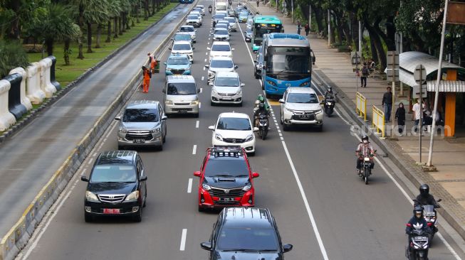 Sejumlah kendaraan bermotor melintas di Jalan Medan Merdeka Barat, Jakarta Pusat, Kamis (19/1/2023). [Suara.com/Alfian Winanto]