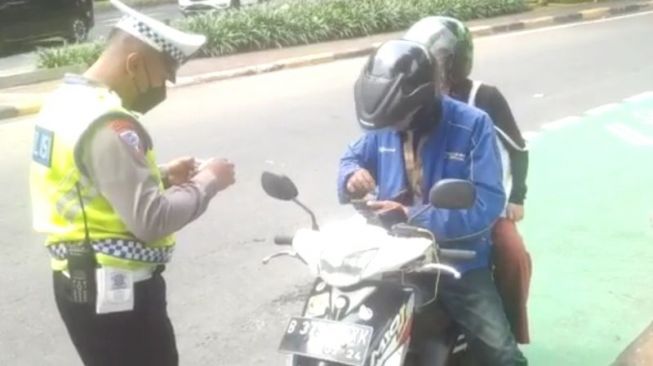  Petugas melakukan teguran dan memberikan imbauan kepada pengendara sepeda motor yang masuk ke jalur cepat di Jakarta Pusat, Kamis (19/1/2023) [screenshot Polda Metro via ANTARA].