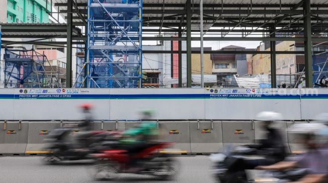 Pekerja menyelesaikan pembangunan Halte TransJakarta di kawasan Jalan Gajah Mada, Jakarta Pusat, Jumat (20/1/2023). [Suara.com/Alfian Winanto]