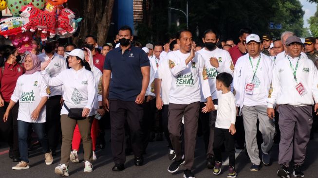 Presiden Joko Widodo (tengah) didampingi Ibu Negara Iriana Joko Widodo (kiri), Ketua DPR Puan Maharani (kedua kiri), Ketua Umum PBNU Yahya Cholil Staquf (kanan) dan dan cucunya Jan Ethes (ketiga kanan) mengikuti jalan sehat dalam rangka menuju satu abad Nahdlatul Ulama (NU) di Solo, Jawa Tengah, Minggu (22/1/2023). [ANTARAFOTO/Maulana Surya/aww]