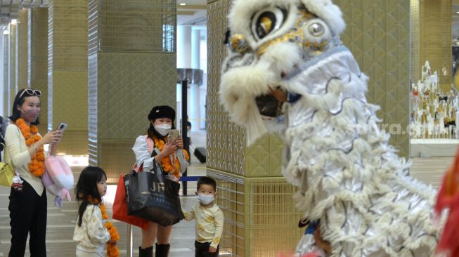 Wisatawan mancanegara asal China disambut kesenian Barongsai setibanya di Terminal Internasional Bandara Internasional I Gusti Ngurah Rai, Badung, Bali, Minggu (22/1/2023). [ANTARA FOTO/Fikri Yusuf/aww]