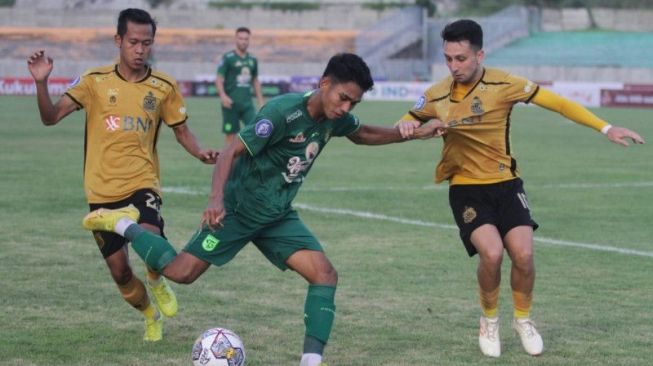 Pemain Persebaya Marselino Ferdinan (tengah) dihalangi pemain Bhayangkara FC Adam Najem (kanan) saat bersiap menendang bola pada pertandingan Liga 1 di Stadion Gelora Joko Samudro, Gresik, Jawa Timur, Senin (23/1/2023). (ANTARA/Moch Asim)