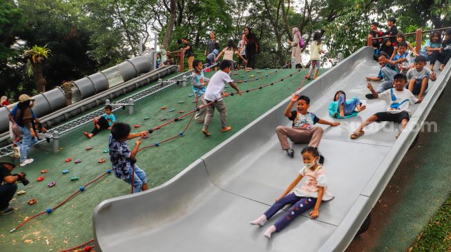 Warga berwisata di Tebet Eco Park, Jakarta Selatan, Senin (23/1/2022).  [Suara.com/Alfian Winanto]