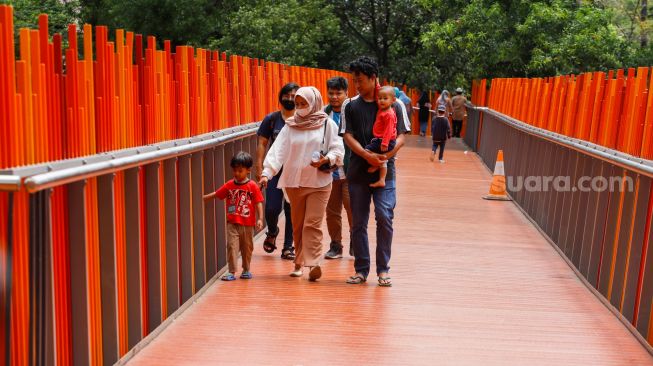 Warga berwisata di Tebet Eco Park, Jakarta Selatan, Senin (23/1/2022).  [Suara.com/Alfian Winanto]