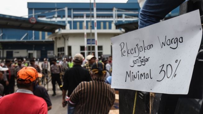 Sejumlah warga membawa poster dalam aksi unjuk rasa di depan Gudang Lazada, Jatijajar, Depok, Jawa Barat, Senin (23/1/2023). [ANTARA FOTO/Asprilla Dwi Adha].