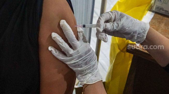 Warga mendapatkan vaksinasi booster wabah Covid-19 kedua dalam Kantor Wali Perkotaan DKI Jakarta Timur, Selasa (24/1/2023). [Suara.com/Alfian Winanto]