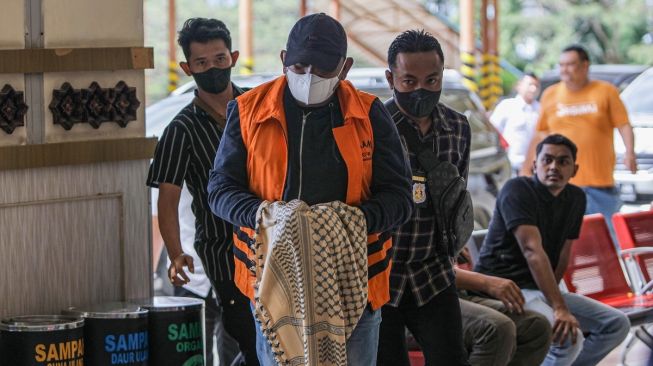 Penyidik Komisi Pemberantasan Korupsi (KPK) menggiring buronan Izil Azhar alias Ayah Merin (tengah) saat tiba di Bandara Internasional Sultan Iskandar Muda (SIM) Aceh Besar, Aceh, Rabu (25/1/2023). [ANTARA FOTO/Khalis Surry].