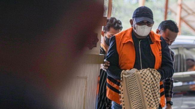 Penyidik Komisi Pemberantasan Korupsi (KPK) menggiring buronan Izil Azhar alias Ayah Merin (tengah) saat tiba di Bandara Internasional Sultan Iskandar Muda (SIM) Aceh Besar, Aceh, Rabu (25/1/2023). [ANTARA FOTO/Khalis Surry].