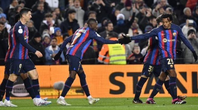 Penyerang Barcelona Ousmane Dembele (Tengah) merayakan golnya dengan pemain belakang Prancis Jules Kounde (kanan) oada laga Copa del Rey (Piala Raja), pertandingan sepak bola perempat final antara FC Barcelona dan Real Sociedad, di stadion Camp Nou di Barcelona pada 25 Januari 2023. Pau BARRENA / AFP