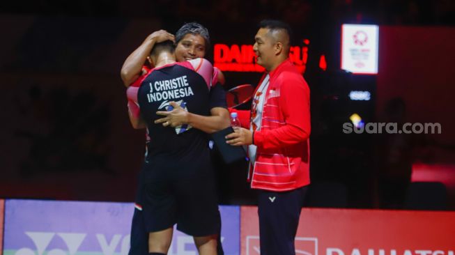 Pebulu tangkis tunggal putra Indonesia Jonatan Christie memeluk pelatihnya, Irwansyah usai berhasil mengalahkan pebulu tangkis tunggal putra China Shi Yu Qi dalam babak Semifinal turnamen Daihatsu Indonesia Masters 2023 di Istora Senayan, Jakarta Pusat, Sabtu (28/1/2023). [Suara.com/Alfian Winanto]