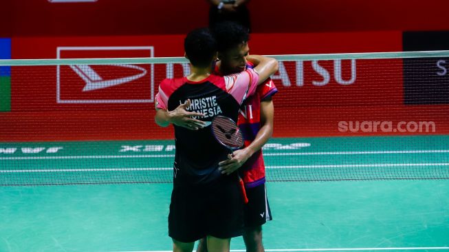 Pebulu tangkis tunggal putra Indonesia Chico Aura Dwi Wardoyo memeluk lawannya sesama tunggal putra Indonesia Jonatan Christie usai dikalahkan dalam babak final turnamen bulutangkis Indonesia Masters 2023 di Istora Senayan, Jakarta, Minggu (29/1/2023). [Suara.com/Alfian Winanto]