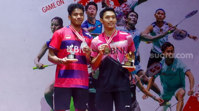 Pebulu tangkis tunggal putra Indonesia Jonatan Christie (kanan) dan Chico Aura Dwi Wardoyo (kiri) berpose dengan medali juara tunggal putra turnamen bulutangkis Daihatsu Indonesia Masters 2023 di Istora Senayan, Jakarta, Minggu (29/1/2023). [Suara.com/Alfian Winanto]