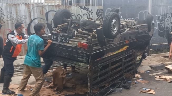 Diduga Rem Blong, Mobil Bak Pengangkut Air Mineral Terbalik di Jalan Panjang