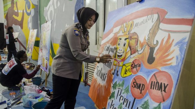 Anggota Polwan Polda Jabar melukis dalam Festival Mural Pemilu Kondusif dan Humanis di GOR Arcamanik Youth Center, Bandung, Jawa Barat, Selasa (31/1/2023). [ANTARA FOTO/Novrian Arbi].