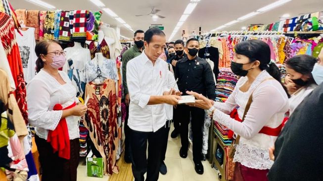 Presiden Joko Widodo atau Jokowi memberikan batuan pada pedagang di Pasar Seni Sukawati di Kabupaten Gianyar, Bali, Rabu (1/2/2023). [Laily Rachev - Biro Pers Sekretariat Presiden]