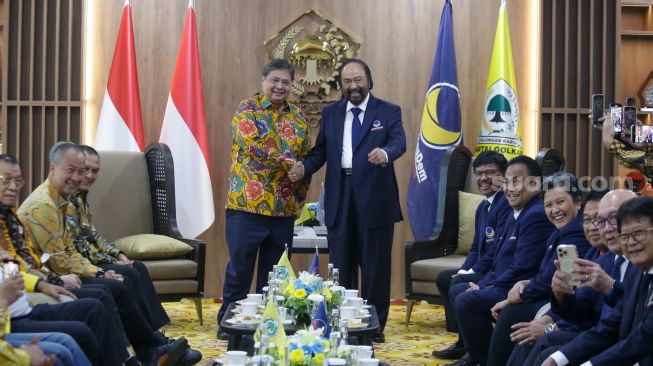 Ketua Umum Partai NasDem Surya Paloh (kanan) berjabat tangan dengan Ketua Umum Partai Golkar Airlangga Hartarto (kiri) saat bertemu di kantor DPP Partai Golkar, Jakarta Barat, Rabu (1/2/2023). [Suara.com/Alfian Winanto]