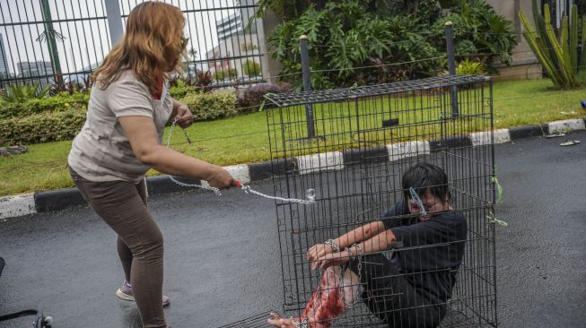 Pengunjuk rasa yang tergabung dalam Koalisi Sipil untuk UU PPRT menggelar aksi teaterikal di depan gedung DPR, Jakarta, Rabu (1/2/2023). [ANTARA FOTO/Galih Pradipta].