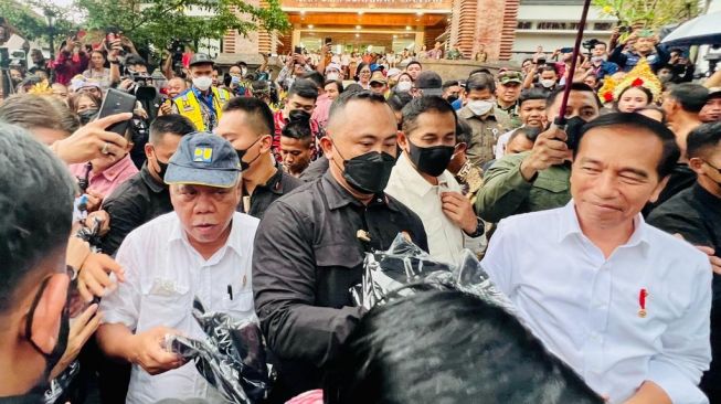 Presiden Joko Widodo atau Jokowi bagi-bagi kaos presiden di sela-sela peresmian revitalisasi Pasar Seni Sukawati di Kabupaten Gianyar, Bali, Rabu (1/2/2023). [Laily Rachev - Biro Pers Sekretariat Presiden]