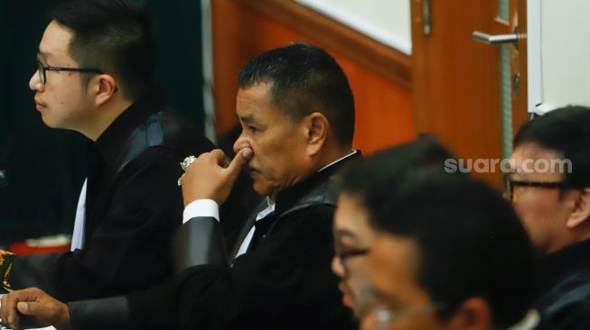 Pengacara kondang Hotman Paris Hutapea (tengah) yang bertindak sebagai kuasa hukum terdakwa kasus narkoba Teddy Minahasa saat mengikuti sidang di Pengadilan Negeri Jakarta Barat, Kamis (2/2/2023). [Suara.com/Alfian Winanto]
