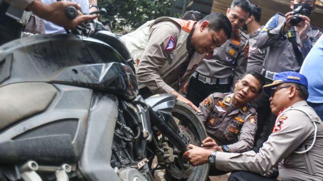 Sejumlah polisi melakukan pengecekan motor yang digunakan mahasiswa UI Mohammad Hasya saat kecelakaan di Jalan Srengseng Sawah, Jagakarsa, Jakarta Selatan, Kamis (2/2/2023). [ANTARA FOTO/Asprilla Dwi Adha].
