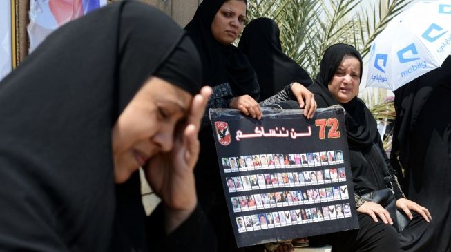 Keluarga korban kerusuhan Stadion Port Said, Mesir pada Februari 2012 berkumpul di luar pengadilan di Kairo pada 9 Juni 2015 saat mereka menunggu putusan akhir dalam persidangan ulang penggemar sepak bola atas kerusuhan yang menelan 74 nyawa. rakyat. Pengadilan menguatkan hukuman mati terhadap 11 penggemar sepak bola. Kerusuhan Port Said, kerusuhan terkait olahraga paling mematikan di negara itu, pecah ketika pendukung tim tuan rumah Al-Masry dan Al-Ahly bentrok setelah pertandingan liga utama antara kedua klub. FOTO AFP / MOHAMED EL-SHAHEDMOHAMED EL-SHAHED / AFP