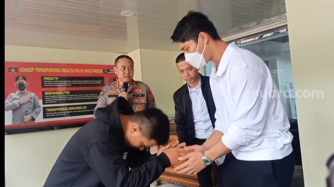 Rizky Billar dan tersangka pengancaman berinisial A (Hoodie hitam) di Polda Metro Jaya pada Jumat (3/2/2023). [Suara.com/Rena Pangesti]