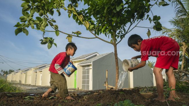 Anak-anak menyiram pohon di lingkungan rumah bersubsidi pemerintah yang disalurkan Bank BTN di kompleks Perumahan Perum Permata Sukatani, Rajeg, Kabupaten Tangerang, Banten, Minggu (5/2/2023). [Suara.com/Wawan Kurniawan]