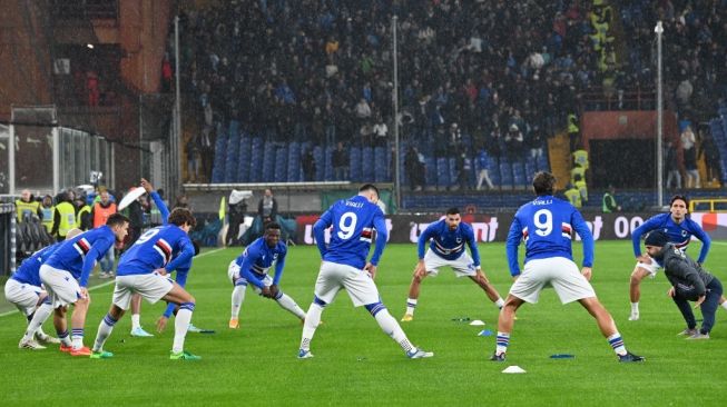 Para pemain Sampdoria yang semuanya mengenakan jersey dengan nama mendiang pesepakbola Italia Gianluca Vialli, melakukan pemanasan sebelum pertandingan Serie A Italia antara Sampdoria vs Napoli pada 8 Januari 2023 di stadion Luigi-Ferraris di Genoa.Andreas SOLARO/AFP