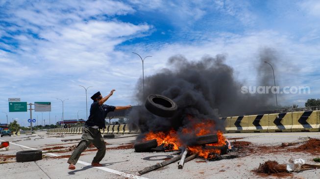 Sejumlah warga melakukan aksi menutup akses jalan menuju Gerbang Tol (GT) Jatikarya 1 dan 2, di ruas Jalan tol Cimanggis-Cibitung, Bekasi, Jawa Barat, Rabu (8/2/2023). [Suara.com/Alfian Winanto]