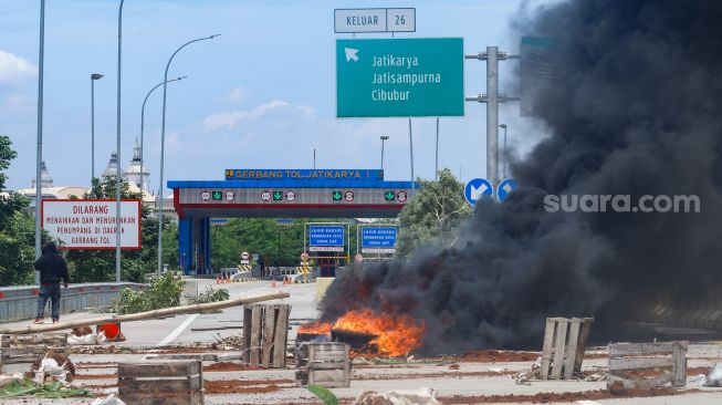 Sejumlah warga melakukan aksi menutup akses jalan menuju Gerbang Tol (GT) Jatikarya 1 dan 2, di ruas Jalan tol Cimanggis-Cibitung, Bekasi, Jawa Barat, Rabu (8/2/2023). [Suara.com/Alfian Winanto]