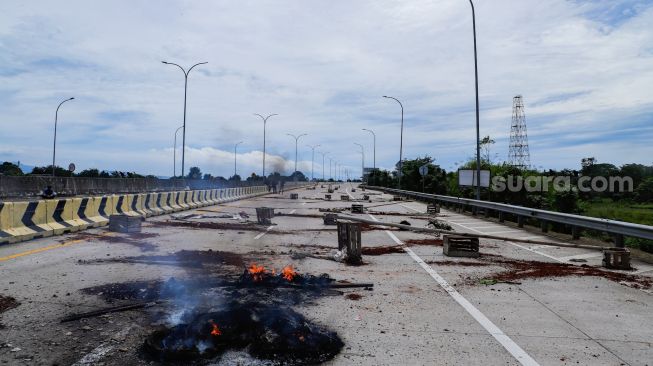 Sejumlah warga melakukan aksi menutup akses jalan menuju Gerbang Tol (GT) Jatikarya 1 dan 2, di ruas Jalan tol Cimanggis-Cibitung, Bekasi, Jawa Barat, Rabu (8/2/2023). [Suara.com/Alfian Winanto]