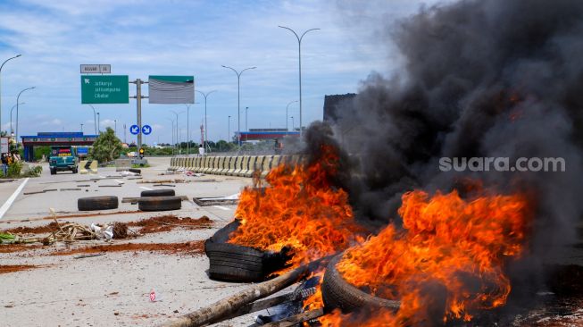 Sejumlah warga melakukan aksi menutup akses jalan menuju Gerbang Tol (GT) Jatikarya 1 dan 2, di ruas Jalan tol Cimanggis-Cibitung, Bekasi, Jawa Barat, Rabu (8/2/2023). [Suara.com/Alfian Winanto]