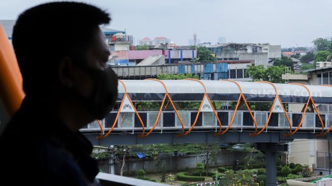 Sejumlah pejalan kaki melintasi Skywalk di kawasan Kebayoran Lama, Jakarta Selatan, Jumat (10/2/2023). [Suara.com/Alfian Winanto]