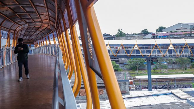 Sejumlah pejalan kaki melintasi Skywalk di kawasan Kebayoran Lama, Jakarta Selatan, Jumat (10/2/2023). [Suara.com/Alfian Winanto]