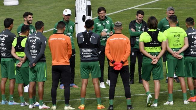 Pelatih tim sepak bola Bolivia Gustavo Costas (tengah) berbicara dengan para pemainnya selama sesi latihan di stadion Hernando Siles di La Paz pada 15 November 2022, menjelang pertandingan persahabatan melawan Peru 19 November di Arequipa, Peru.AIZAR RALDES / AFP