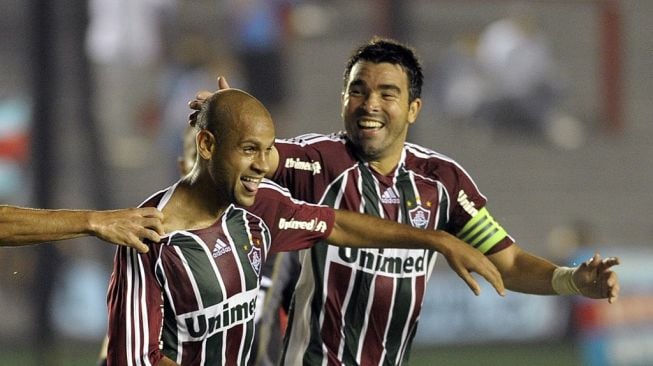 Bek Fluminense Carlinhos (kiri) merayakan dengan rekan setimnya,  Deco setelah mencetak gol melawan klub Argentina Arsenal FC selama pertandingan Grup 4 Copa Libertadores 2012 mereka di stadion Arsenal di Sarandi, Buenos Aires, Argentina, pada 18 April 2012. AFP PHOTO / Juan MabromataJUAN MABROMATA/AFP