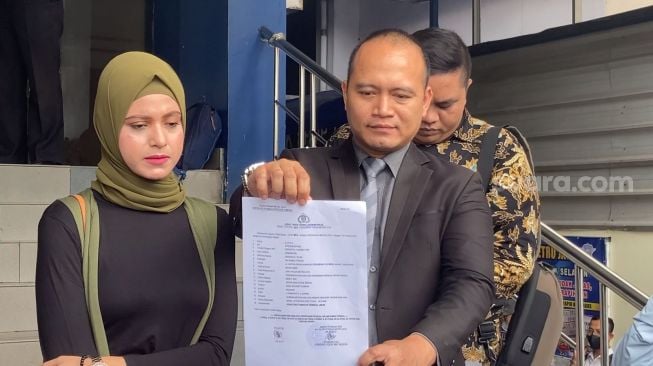 Istri Rizal Djibran, Sarah ditemani kuasa hukumnya, Tris Haryanto di Polda Metro Jaya, Jakarta, Senin (13/2/2023) [Suara.com/Adiyoga Priyambodo]