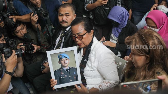 Ibunda Brigadir Yosua Hutabarat, Rosti Simanjuntak, membawa foto mendiang putranya saat menghadiri langsung sidang vonis terdakwa pembunuh anaknya Ferdy Sambo di Pengadilan Negeri Jakarta Selatan, Senin (13/2/2023). [Suara.com/Alfian Winanto]