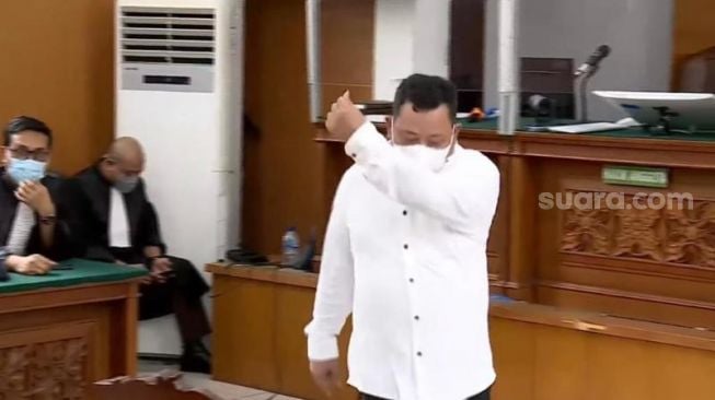 Kuat Maruf pamer lovesign saranghaeyo saat menjalani sidang vonis kasus Brigadir J di PN Jakarta Selatan. (Suara.com/M Yasir)