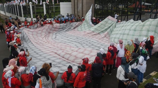 Aktivis membawa poster dalam aksi damai memperingati Hari Pekerja Rumah Tangga di depan kompleks Parlemen, Senayan, Jakarta, Rabu (15/2/2023). [ANTARA FOTO/Aditya Pradana Putra].