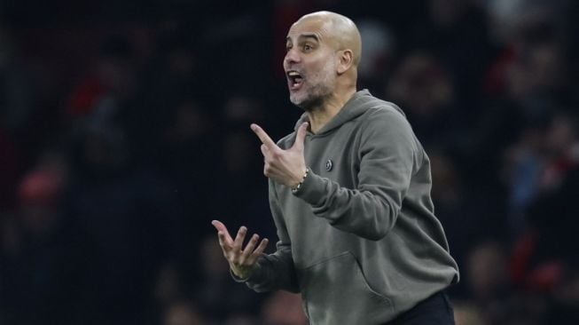 Gestur manajer Manchester City, Pep Guardiola pada laga Liga Inggris kontra Arsenal di Stadion Emirates, London, Kami (16/2/2023) dini hari WIB. [Ian Kington / IKIMAGES / AFP]