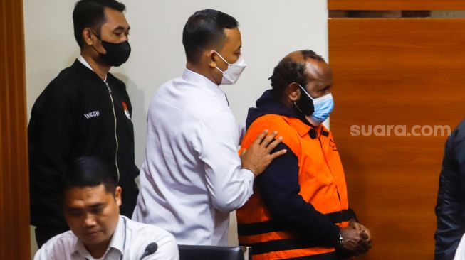 Tersangka Bupati Nonaktif Mamberamo Tengah, Papua, Ricky Ham Pagawak berjalan mengenakan rompi tahanan saat dihadirkan dalam konferensi pers pengumuman penahanan tersangka di Gedung Merah Putih KPK, Jakarta Selatan, Senin (20/2/2023). [Suara.com/Alfian Winanto]