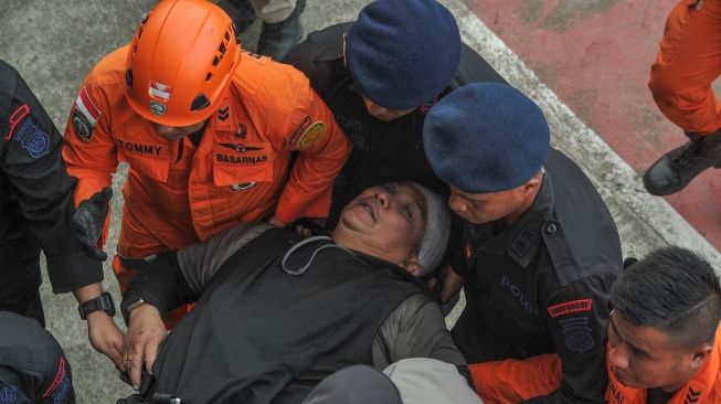 Petugas mengevakuasi Dirpolairud Kombes Pol Michael Mumbunan menggunakan tandu setibanya di Stadion Merangin, Jambi, Selasa (21/2/2023). [ANTARA FOTO/Wahdi Septiawan].