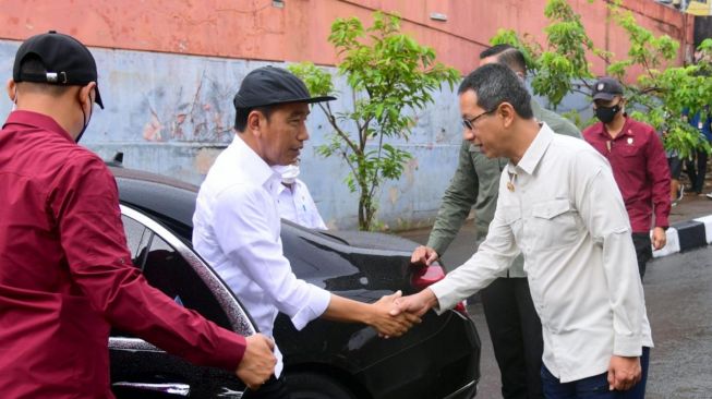 Presiden Joko Widodo atau Jokowi berjabat tangan dengan PJ Gubernur Jakarta Heru Budi Hartono saat meninjau lokasi normalisasi Kali Ciliwung di Cikoko, Jakarta, Selasa (21/2/2023). [Foto: Muchlis Jr - Biro Pers Sekretariat Presiden]
