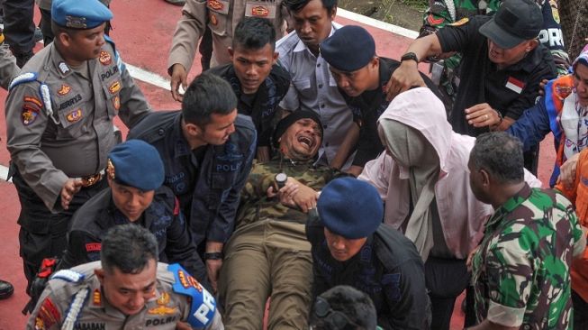 Petugas mengevakuasi Dirreskrimum Polda Jambi Kombes Pol Andri Ananta menggunakan tandu setibanya di Stadion Merangin, Jambi, Selasa (21/2/2023). [ANTARA FOTO/Wahdi Septiawan].